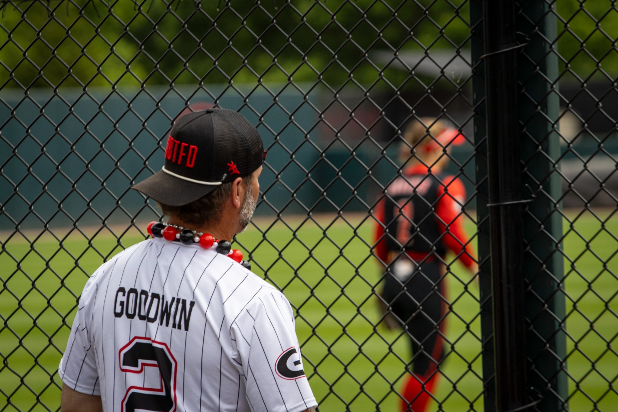Jay watching Shorty play softball through the fence